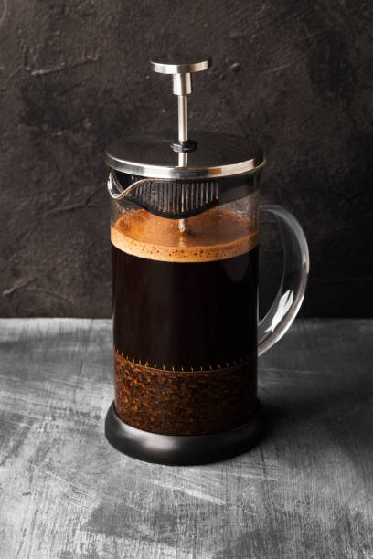 istock Coffee in french press on dark background 1150534076