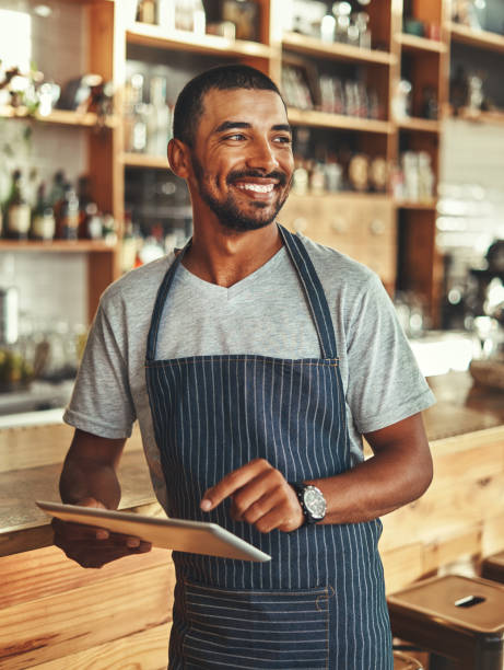 istock Young male owner holding digital tablet while standing in cafe 1150534113