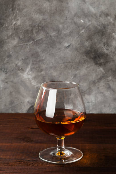 istock Cognac in glass on wooden background 1150536244