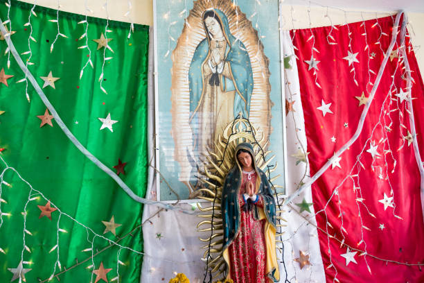 Rio Lagartos, Mexico - February 14: Statue of the Virgin Mary in front of a Mexican flag in a bus station in Rio Lagartos, Mexico on February 14, 2017