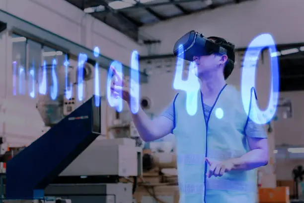 Factory and manufacturing engineering worker wearing VR goggle headset touching Industrial 4.0 text on virtual reality