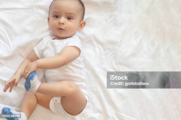 68 Month Old Baby Boy Lying Playfully In Bed Stock Photo - Download Image Now - 0-11 Months, 6-11 Months, Arm