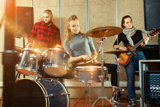 istock Passionate emotional female drummer with her bandmates practicin 1150538836