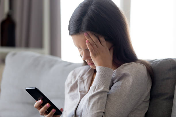 istock Confused woman sitting on couch received message feels disappointed 1150540094