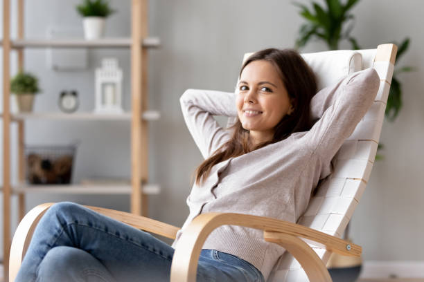 istock Relaxed woman resting on comfortable rocking chair looking at camera 1150540102