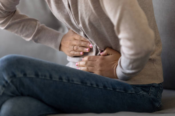 istock Cropped closeup image female touching stomach suffering from severe ache 1150540175