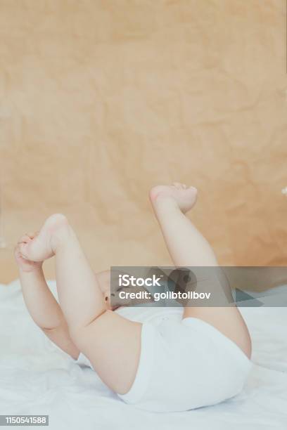 68 Month Old Baby Boy Lying Playfully In Bed Stock Photo - Download Image Now - 0-11 Months, 6-11 Months, Arm