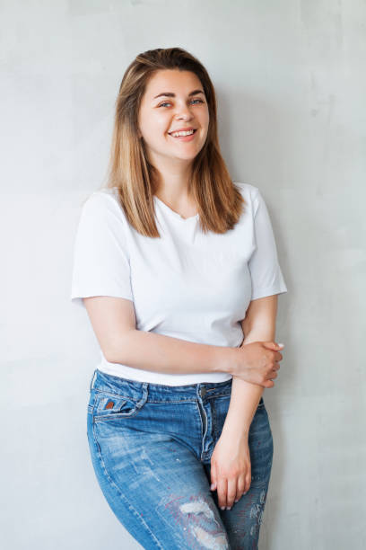 Young beautiful woman in white t-shirt and jeans Portrait of young beautiful woman in white t-shirt and jeans plus size woman fashion laughing stock pictures, royalty-free photos & images