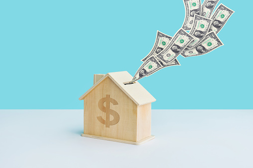 Saving money or financial concepts with home piggy bank and dollar bill on pastel color background.