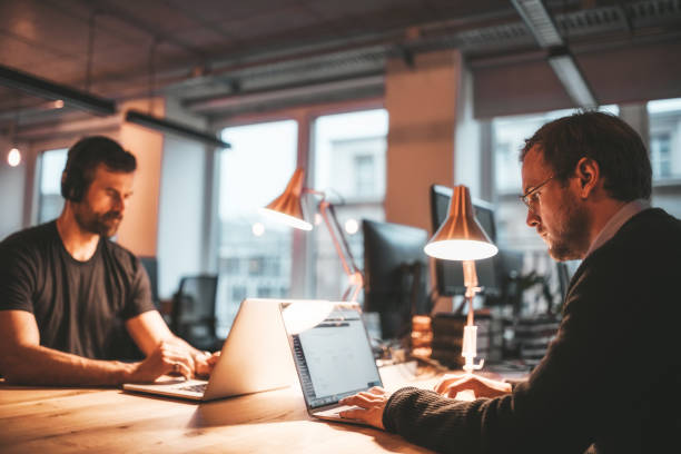 istock two business people at work desk in the evening 1150543266