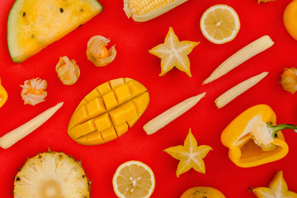 Flatlay of various yellow and orange fruits and vegetables knolled