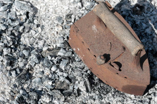 istock Rare iron working on coals. Against the background of extinct coals. 1150545857