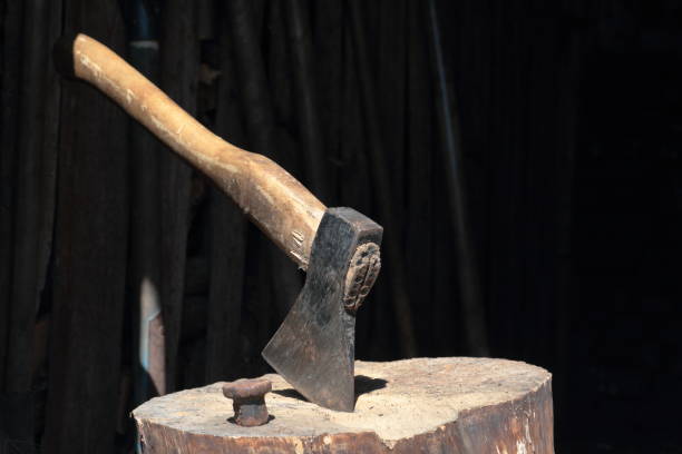 istock The ax is hammered into a wooden deck.  Next is a hammered anvil for riveting a scythe. 1150547441