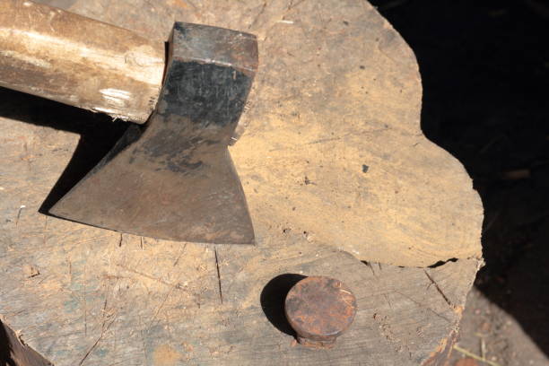 istock The ax is hammered into a wooden deck.  Next is a hammered anvil for riveting a scythe. 1150547451