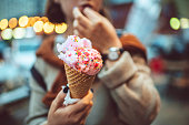 Teen girl with pink eating ice-cream outdoors in summer