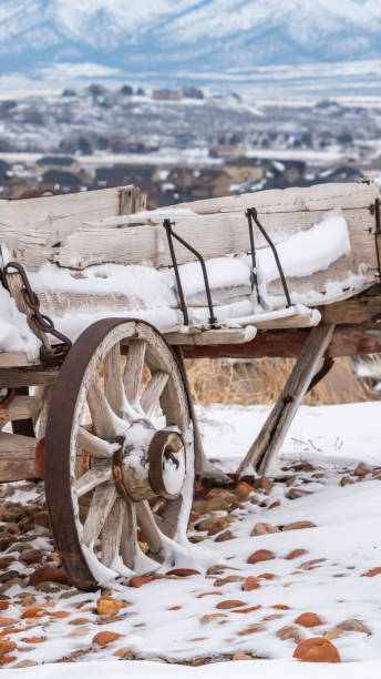 istock Vertical Old wooden wagon with chains and rusty wheels dusted with snow in winter 1150549073