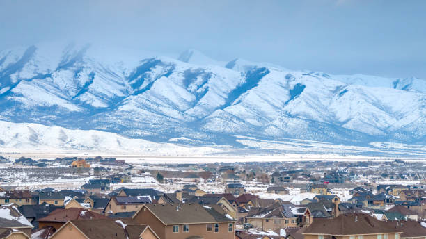 istock Panorama Homes with a snowy mountain and cloudy sky background viewed in winter 1150549083