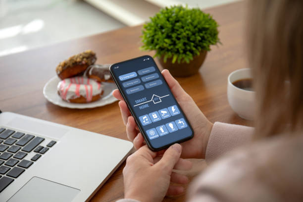 istock female hands holding phone with app smart home on screen 1150553043