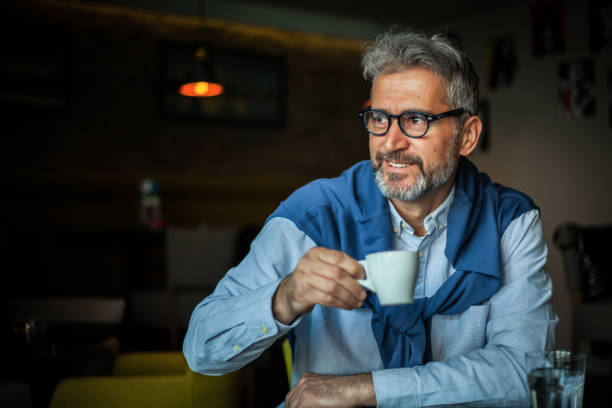istock Senior man enjoys coffee at a coffee shop 1150554832