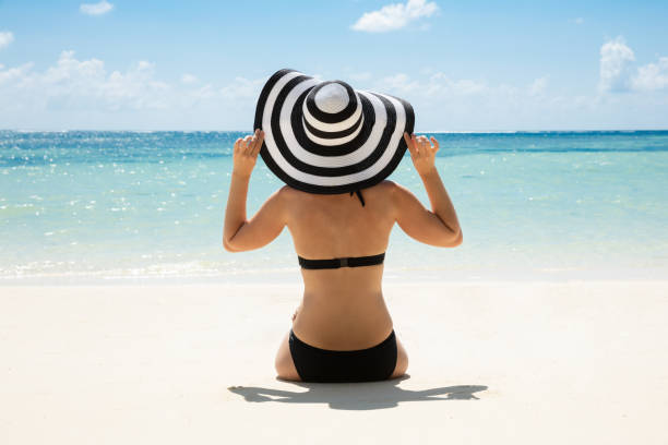 istock Woman In Bikini Looking At Ocean Wearing Sun Hat 1150556609