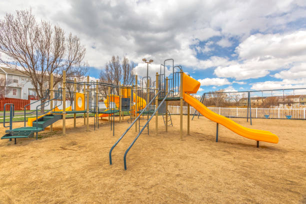 istock Playground with slides and swings under the blue sky filled with puffy clouds 1150556774