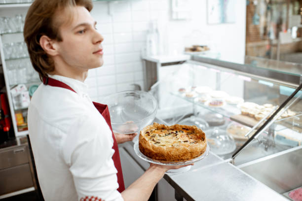 istock Salesman with pie at the pastry shop 1150560429