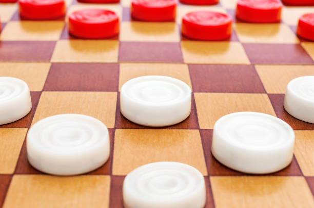 istock Rows of checkers on wooden checkerboard. Play draughts. 1150562111