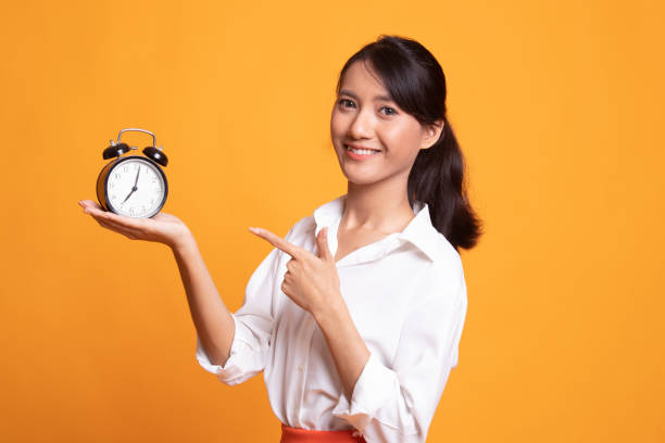 istock Young Asian woman point to a clock. 1150563539
