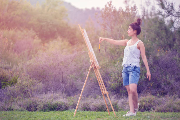 istock Young woman painting in a forest 1150563822