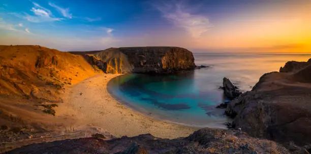 Photo of Romantic sunset over the beautiful, natural and sandy beach of Papagayo on Lanzarote