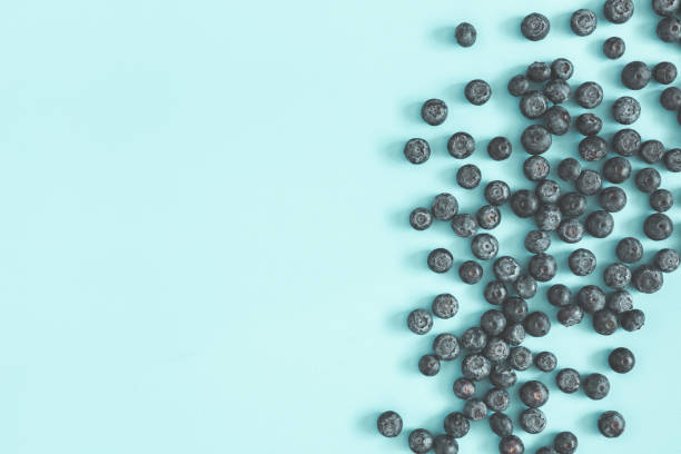 istock Blueberry on blue background. Flat lay, top view 1150565683