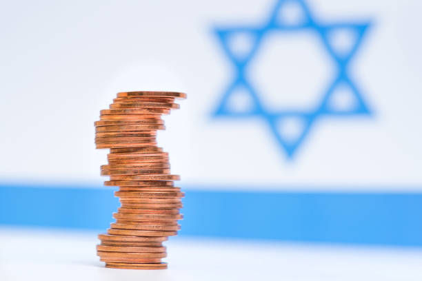 istock Coins stacked on each other in different positions on blue and white background. Israeli economy. 1150565787