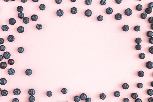 Blueberry on pink background. Flat lay, top view