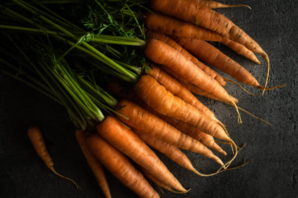 морковь нанта на rustic dark background. свежие органические суперпродуктов здоровое питание концепции и борьбы с диабетом. - carotene healthy eating macro close up стоковые фото и изображения
