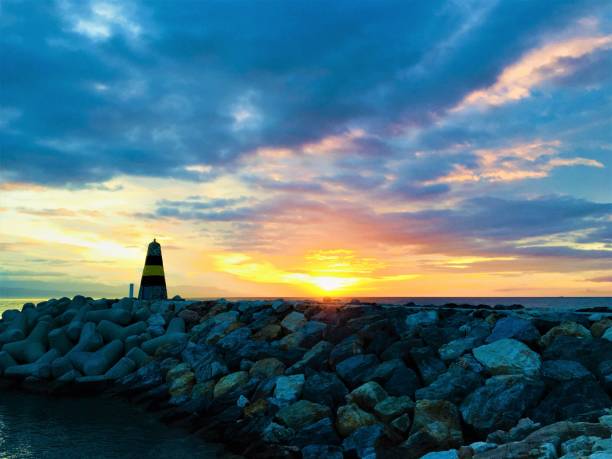 istock Sunrise with lighthouse on jetty, Costa del Sol, Benalmadena, Spain 1150567135