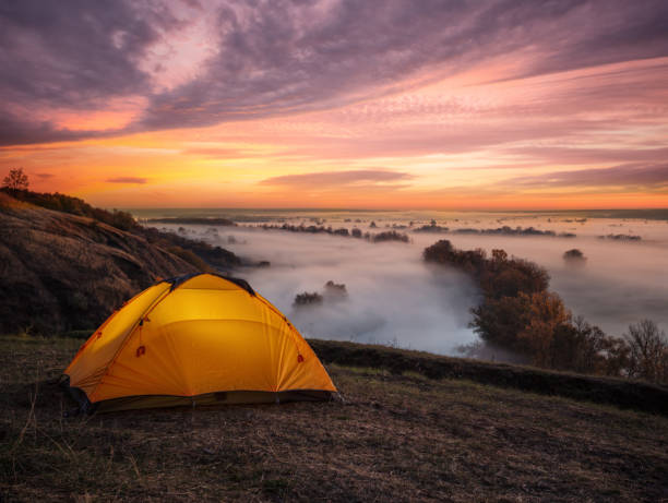 istock Orange illuminated from inside tent above river at sunset 1150567402