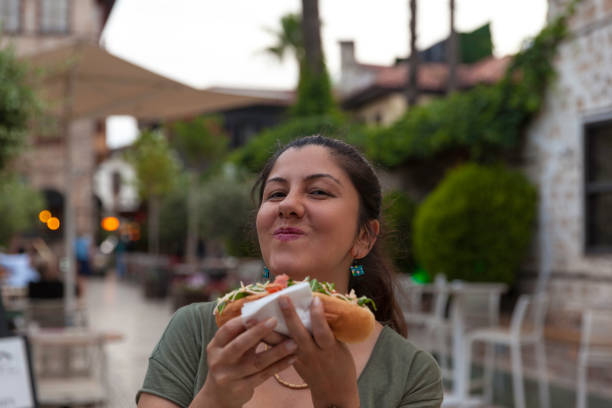 Portrait of women holding hot dog in old town Portrait of women holding hot dog in old town turkish sausage stock pictures, royalty-free photos & images