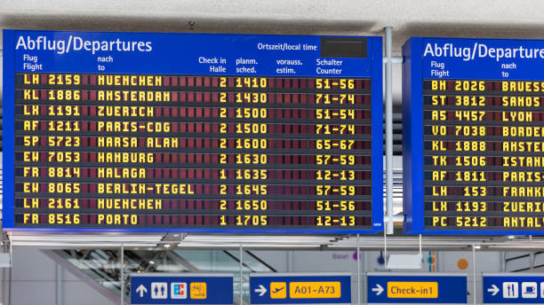 istock Airport flight information displayed on departure board, flight status changing. Flight schedule screen at airport showing different destinations. 1150571612