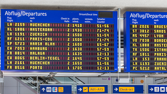 Airport flight information displayed on departure board, flight status changing. Flight schedule screen at airport showing different destinations.