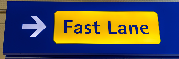 Fast Lane sign in blue and yellow at the airport close up. Fast Lane sign airport first class luxury notification.