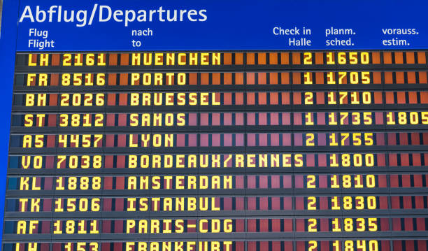 istock Airport flight information displayed on departure board, flight status changing. Flight schedule screen at airport showing different destinations. 1150571617