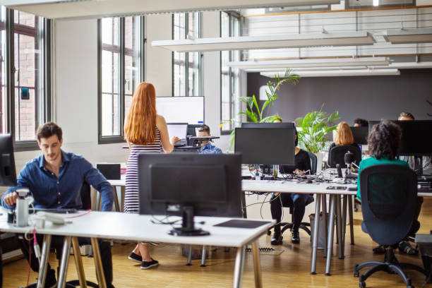 多忙なオープンプランのオフィスで働くビジネスマン - office furniture open plan desk ストックフォトと画像