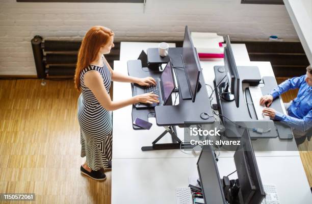 Woman Working At Ergonomic Standing Desk Stock Photo - Download Image Now - Standing Desk, Ergonomics, Office