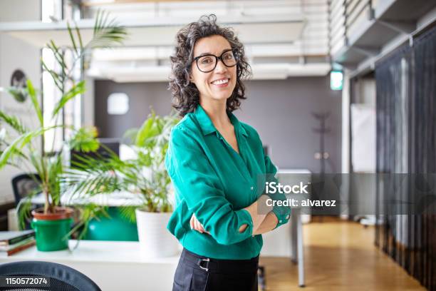 Portrait Of Confident Mature Businesswoman In Office Stock Photo - Download Image Now