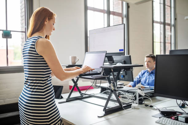 femme d’affaires travaillant au bureau debout ergonomique - bureau lieu de travail photos et images de collection