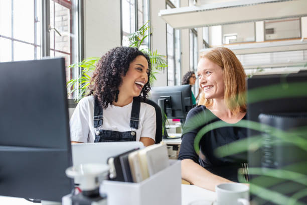 Smiling female colleagues working together in office
