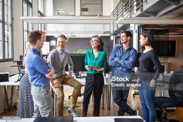 Happy Business Team Having A Standing Meeting In Office Stock Photo - Download Image Now