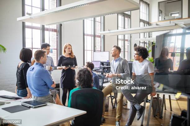 Group Of Professionals Discussing New Business Plan Stock Photo - Download Image Now