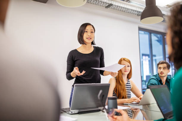同僚と話をする自信のある女性プロフェッショナル - ビジネスマン 日本人 ストックフォトと画像