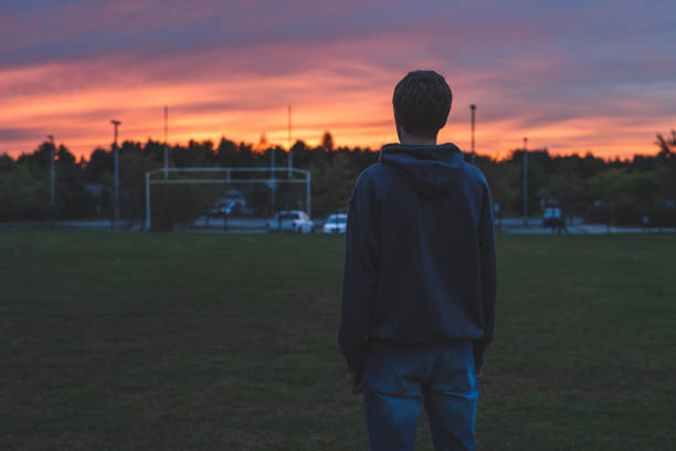 Lonely teenager at sunset. stock photo